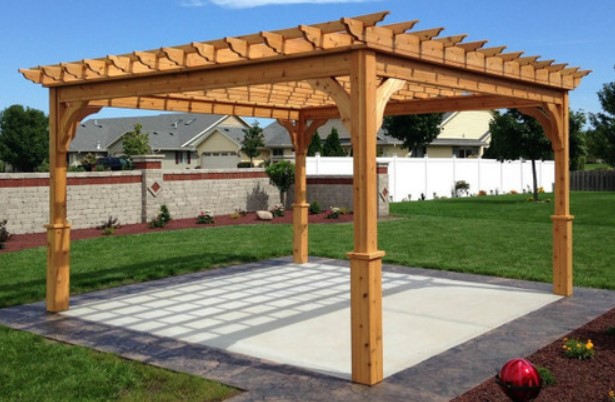  Elegant wood pergola over a patterned paving stone patio in a lush backyard setting.