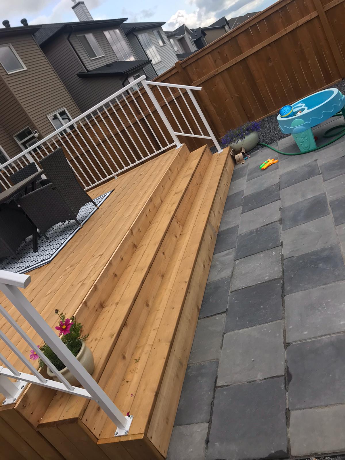 wood stairs landscaping landing onto paving stone patio calgary landscaping