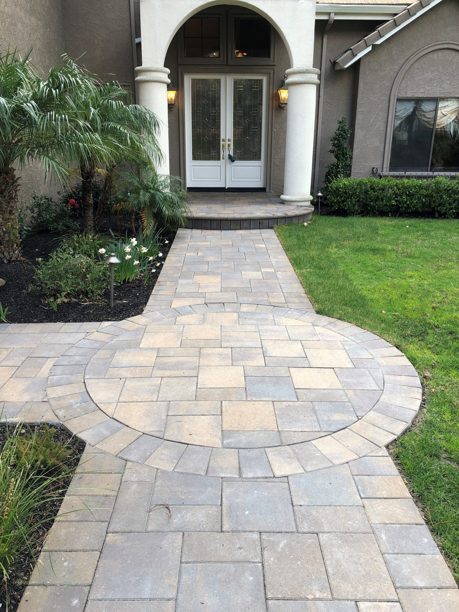 A beautifully landscaped garden pathway adorned with carefully arranged pathway stones, highlighting the expertise of CALGARY landscapers